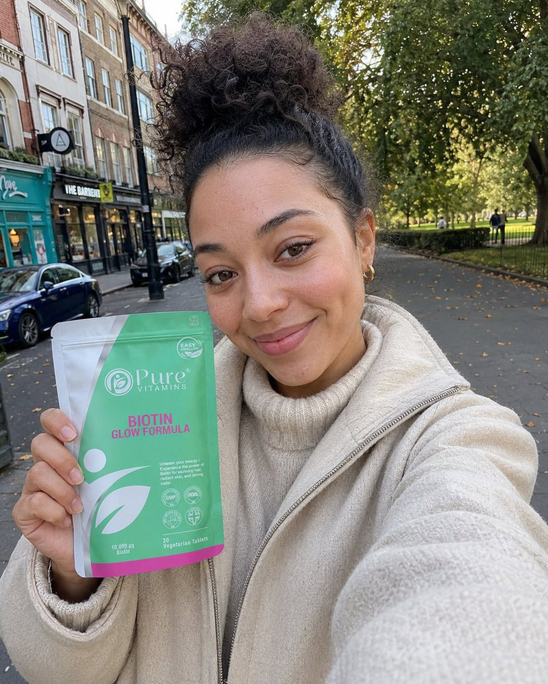Customer holding a pouch of Pure Vitamins Biotin Glow Formula